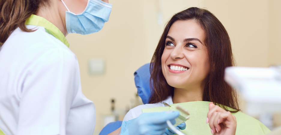 happy smiling woman looking up at female dentist at her dental appointment